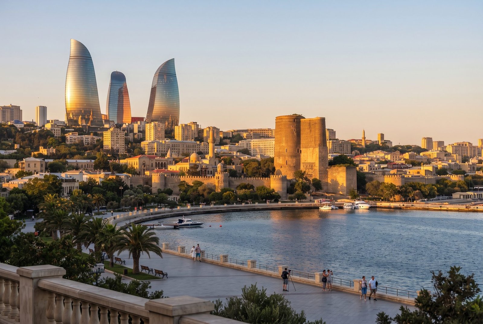 Baku Flame Towers and the Maiden Tower above the old city walls and bay at sunset, Azerbaijan