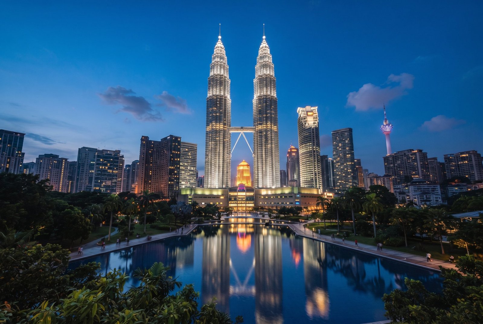 Petronas Twin Towers and city skyline reflected in the park lake at dusk, Kuala Lumpur, Malaysia